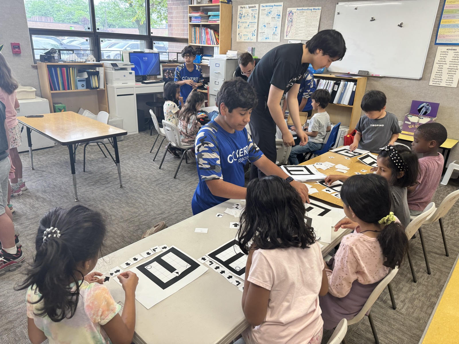 Covert Robotics members teaching young students a hands-on coding activity in a classroom